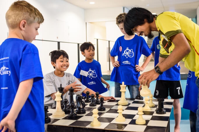 vader leert kinderen schaken