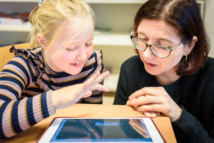 ouder of leerkracht helpt kind bij online leren schaken